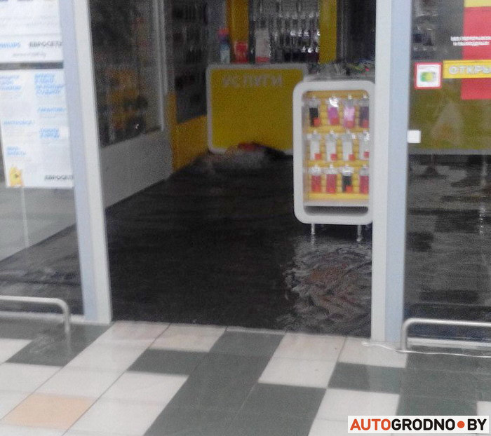 Вода попала внутрь торгового центра. На фото видно, как она под напором вытекает из под пола.